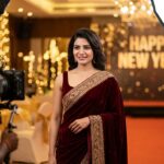 A woman wearing a trendy Red Velvet Saree for a New Year's Eve party